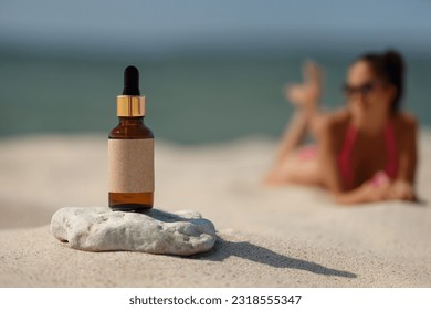 Dropper bottle on the beach. Concept of natural ingredient tanning oil. - Powered by Shutterstock