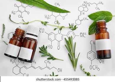 Dropper bottles and herbs on chemical formulas background - Shutterstock ID 455493085