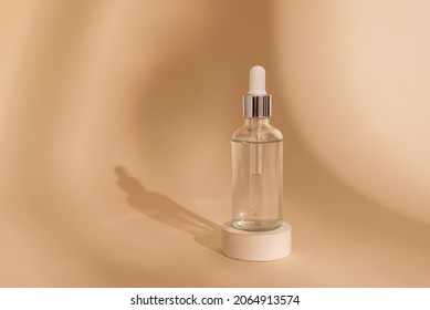 Dropper Glass Bottle Mockup. Сosmetic Pipette On Beige Background With Shadows On Stone Round Podium. Essential Oil