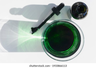 Dropper And Glass Of Chlorophyll Supplement In Water