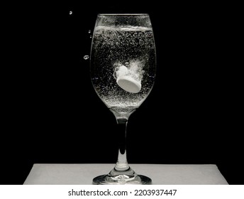Dropping Alka Seltzer In Water Inside A Wine Glass 