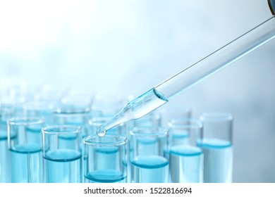 Dropping Sample Into Test Tube With Light Blue Liquid, Closeup