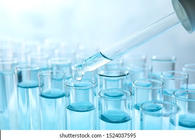 Dropping Sample Into Test Tube With Light Blue Liquid, Closeup