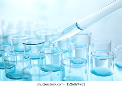 Dropping Sample Into Test Tube With Light Blue Liquid, Closeup