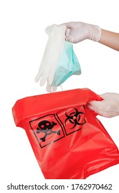 Dropping Used Medical Mask And Medical Gloves In Red Biohazard Bag Isolated On White Background. Concept Of Waste Separation To Prevent Spreading Of Coronavirus Infection.