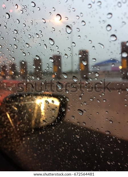 Drops of heavy rain on a car\'s window. Driving in\
the rain on the wet road