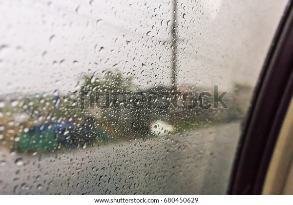 Drops of heavy rain on a car\'s window. Driving in\
the rain on the wet road