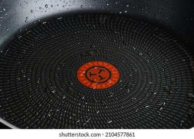 Drops of olive oil in a frying pan with non-stick coating.