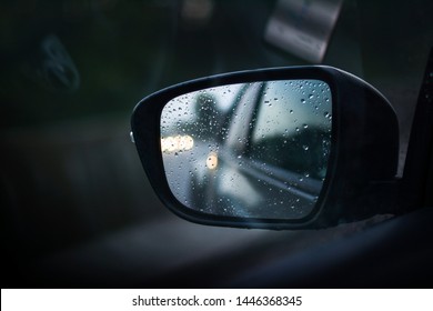 Drops on the car mirror after driving during the rain 