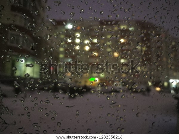 Drops on the glass in the car overlooking the\
evening courtyard