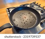 Drops on Teflon coated pan on stove. Potential dangerous chemicals in cookware, non stick frying. PFAS or  perfluoroalkyl. Part of a serie.