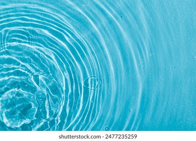 drops on water with circles on a blue background close up