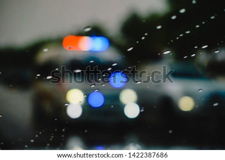 Drops Of Rain On Blue Glass Background. Street Bokeh Lights Out Of Focus. Autumn Abstract Backdrop.