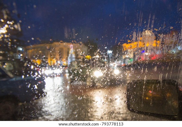 Drops Of Rain On Glass Background. Street\
Bokeh Lights Out Of Focus. Autumn Abstract Backdrop. Rainy days,\
rain background