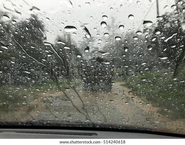 Drops of rain on glass , rain drops on\
clear window in heavy rain Malaysia\
road