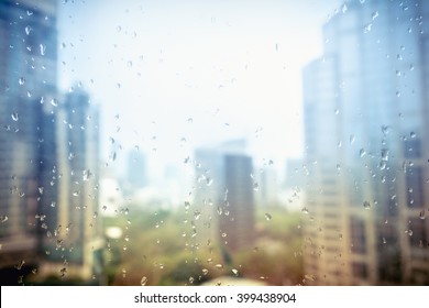 Drops of rain on glass with urban background / drops on glass after rain - Powered by Shutterstock