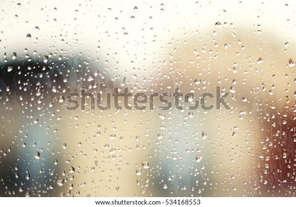 Drops Of Rain On Window as Background. Rainy\
autumn day. Soft colors