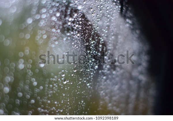 Drops\
of rain on a window glass on a blurred\
background