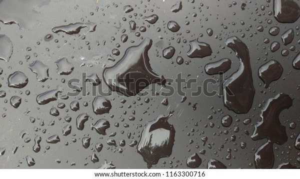 Drops of Rain or Water Drop on the Hood of the Car.\
Rain Drops on the Surface of the Car or on the Iron Surface Flow\
Down.