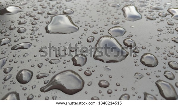 Drops of Rain or\
Water Drop on the Hood of the Car. Rain Drops on the Surface of the\
Car or on the Iron Surface Flow Down. Abstract Background and Water\
Texture for Design.