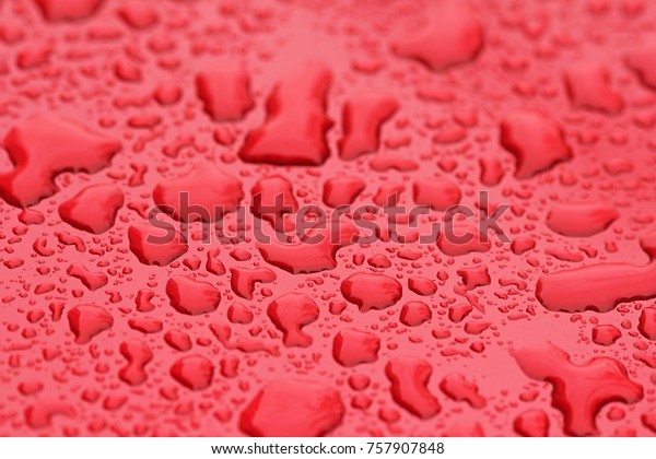 Drops of Rain or\
Water Drop on the Hood of the Red Car. Rain Drops on the Surface of\
the Car or on the Iron Surface Flow Down. Abstract Background and\
Water Texture for Design.