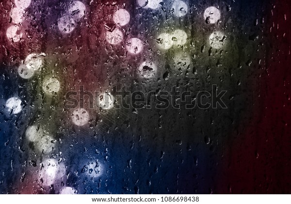 Drops Of Rain Water In Night Or Evening Street\
Lights On Glass Background. Street Bokeh Boke Lights Out Of Focus.\
night abstract backdrop