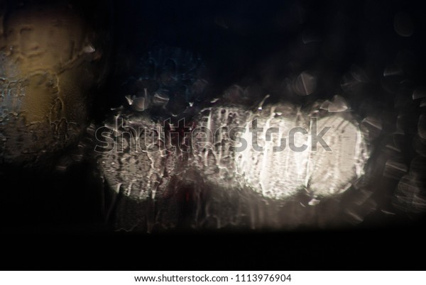 Drops Of Rain Water In Night Or Evening Street\
Lights On Blue Glass\
Background