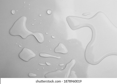 Drops of spilled water on grey background, top view