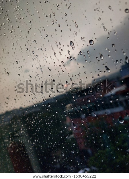 Drops of water condensation on window glass with\
out-focus. Abstract background texture gives Romantic feeling.\
Rainy season, Rain drops on window\'s glass is viewing the downtown\
city skyline.