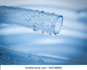 Drops Of Water Drip From Blue Garden Hose