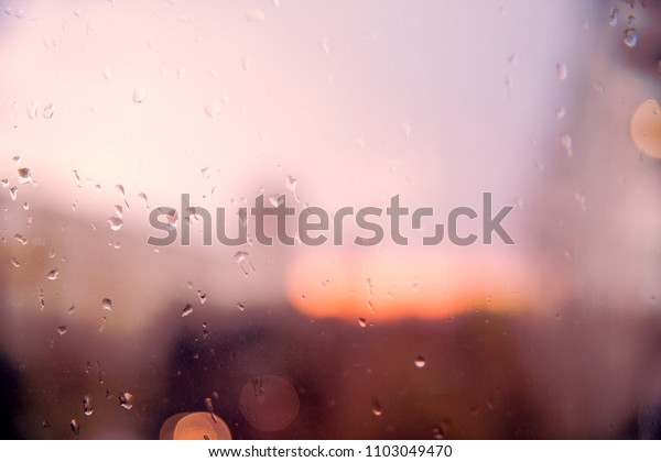  Drops of water during the rain in a city. Glass covered\
with rain. 