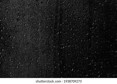Drops of water flow down the surface of the clear glass on a black background. Texture for creativity. - Shutterstock ID 1938709273