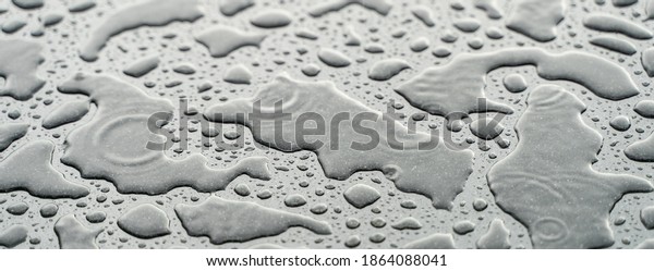 Drops of water on the car after rain. Water\
drops on top of metal\
surface.