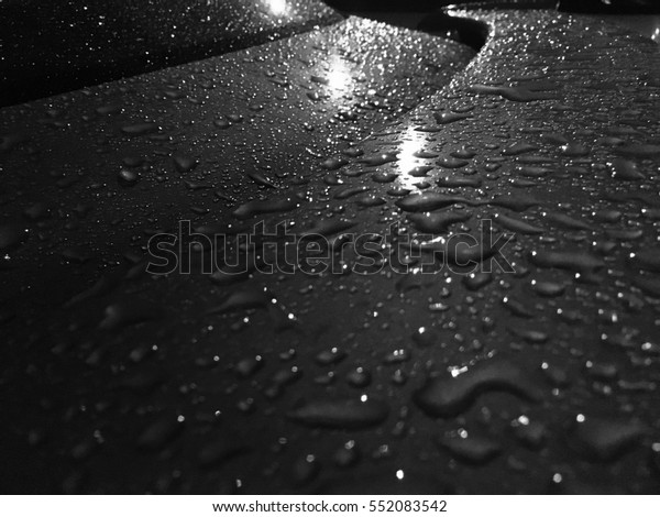 drops of\
water on the car after rain at night and Light from the light bulbs\
makes the water drop visible on the\
car.