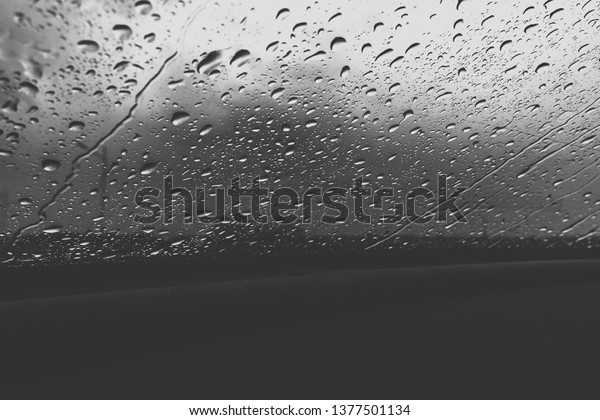 Drops\
of water on the car glass. Rain on the\
windshield.