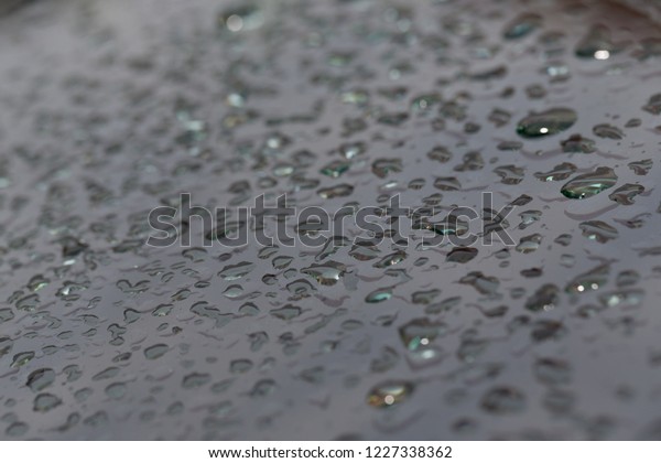 Drops of water on a metal surface
for  background. Selective focus.  Shallow depth of
field.