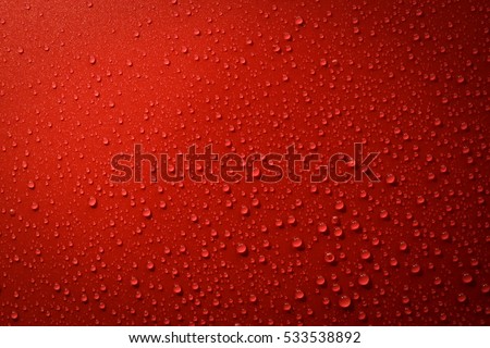 Drops of water on red and black surface. Macro photo, drop, shadow plastic base.