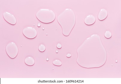 drops of water spilled on a light pink surface