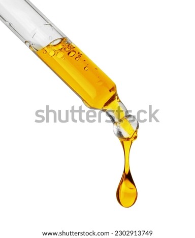 Drops of a yellow oily liquid dripping from a pipette isolated on a white background