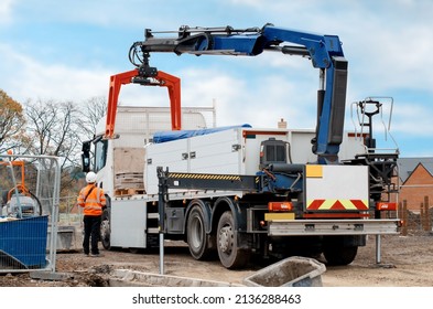 Dropside Flatbed HIAB Crane Lorry With Brick Grab Attachment Deliver Materials On Construction Site And Offloading Them