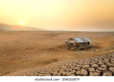 Drought Impact. Landscape Of Dried Lake With Fishing Wooden Raft In Middle Extreme Hot Environment. Climate Change And Global Warming On Summer.