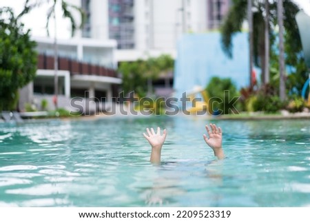 drowning child or kid and people cannot swim to deep water and raise two hands or arm for help on children swimming pool and near death
