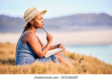 Drowning Dialogues. Shot Of A Young Woman Writing In Her Journal At The Beach.