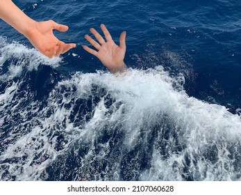 A Drowning Man Asks For Help. Sticking Your Hand Out Of The Sea Water. The Hand Of A Man In The Deep Sea. Concept: Rescue Drowning People, Asking For Help.