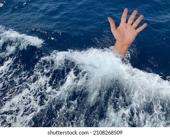 A Drowning Man Asks For Help. Sticking Your Hand Out Of The Sea Water. The Hand Of A Man In The Deep Sea. Concept: Rescue Drowning People, Asking For Help.