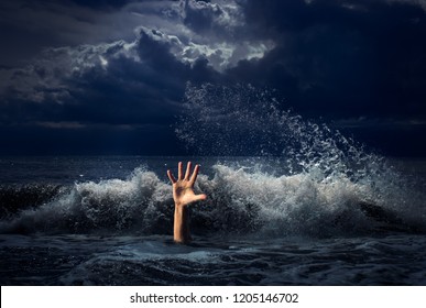 drowning man hand in storm sea water