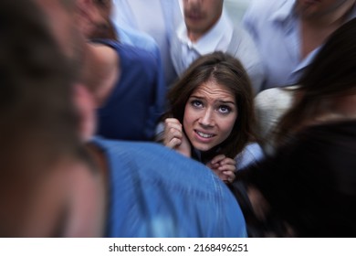 Drowning in people. Shot of a fearful young woman feeling trapped by the crowd.