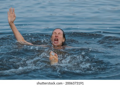 Drowning woman reaching for help in sea