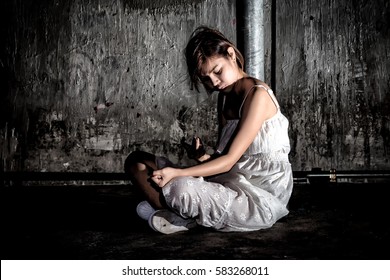 Drug Abuse Concept., Overdose Asian Female Drug Addict Use Syringe Injection Narcotic To Her Hand., In Scary Abandoned Building., In Dark Tone.