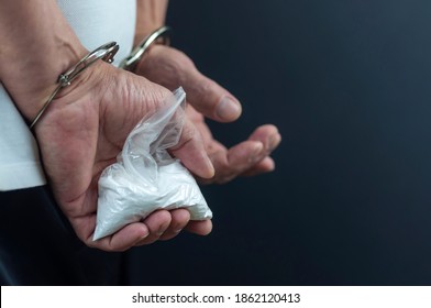 Drug Addict In Handcuffs With A Package Of Drugs In His Hands